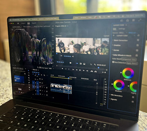 Image of laptop in front of window with Lumetri Color Panel in Premiere pro on screen.