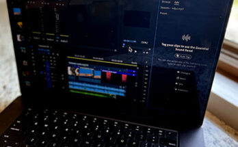 Image of Macbook Pro on quart countertop in front of window with focus on Audio panel in Premiere