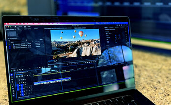 Laptop on table with Premiere Pro editing window open.