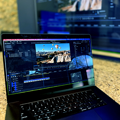 Laptop on table with Premiere Pro editing window open.