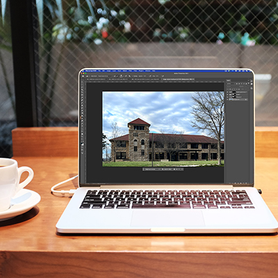 Image of laptop with Photoshop open and Adjustment brush being used