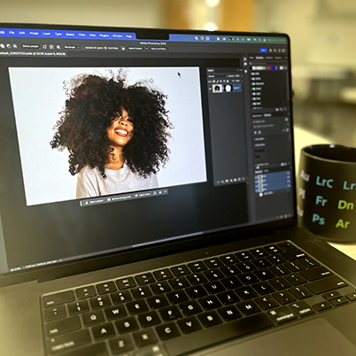 Image of laptop in classroom with Photoshop open and cut out photo shown.