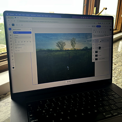Laptop on counter with Photoshop on the web open in editing