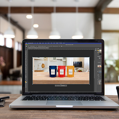 Image of laptop in workspace with Photoshop on the screen showing harmonize.