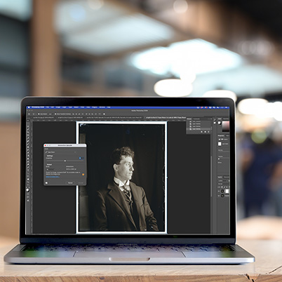 Laptop on a desk in a large room. Photoshop open showing upscale