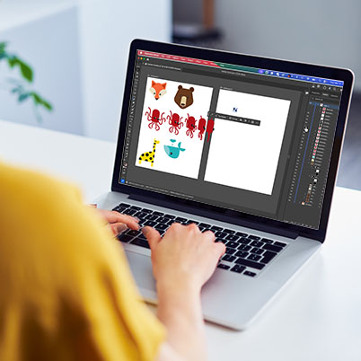 Image of woman working at table with laptop and screen showing Illustrator turntable.